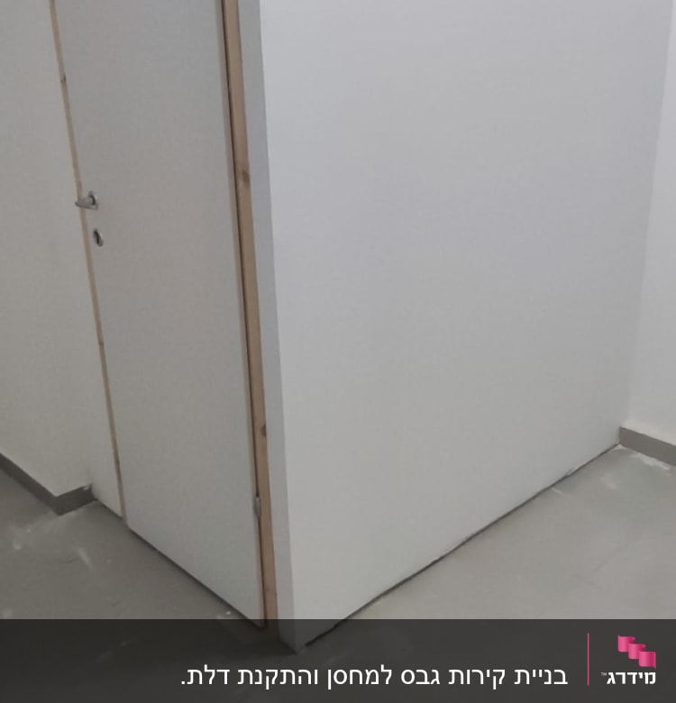 קיר גבס לבן עם דלת עץ צמודה